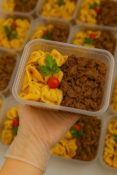 Marmita embalada com proteína de carne e massa de tortéi/capeletti, representando pratos de alta aceitação no mercado de marmitaria fit.
